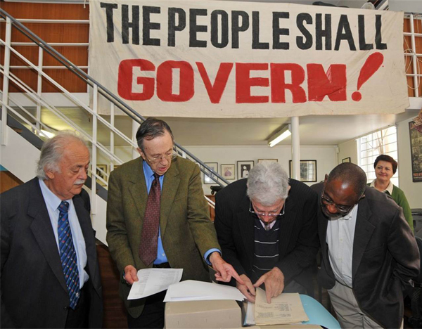 George Bizos, Joel Joffe, Arthur Chaskalson and Loyiso Nongxa view the original Rivonia Trial papers