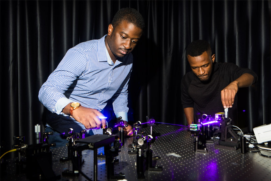 Bienvenu Ndagano (left) and Isaac Nape working on the quantum experiment. Credit: Wits University