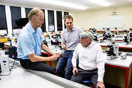 Professors Roger Gibson (left) and Lewis Ashwal (right) discussing their preliminary assessment of the Benenitra meteorite with Tim Marais. Credit: Wits University