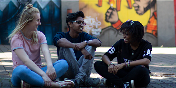 Three students sitting on ground and talking © Shivan Parusnath