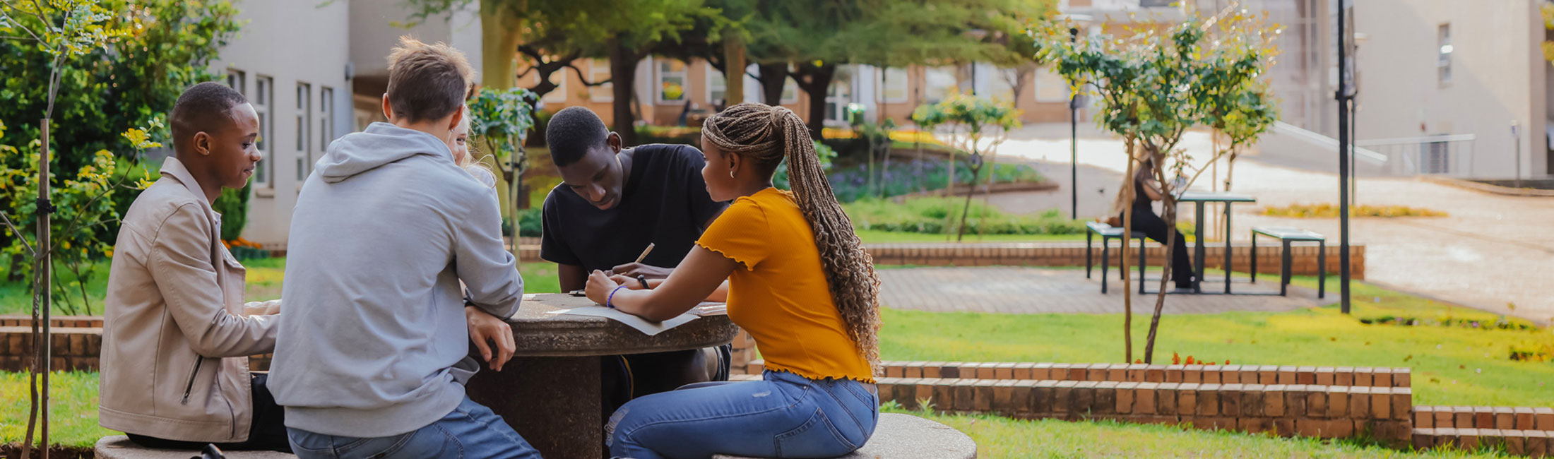 Students talking around a table on Wits West Campus