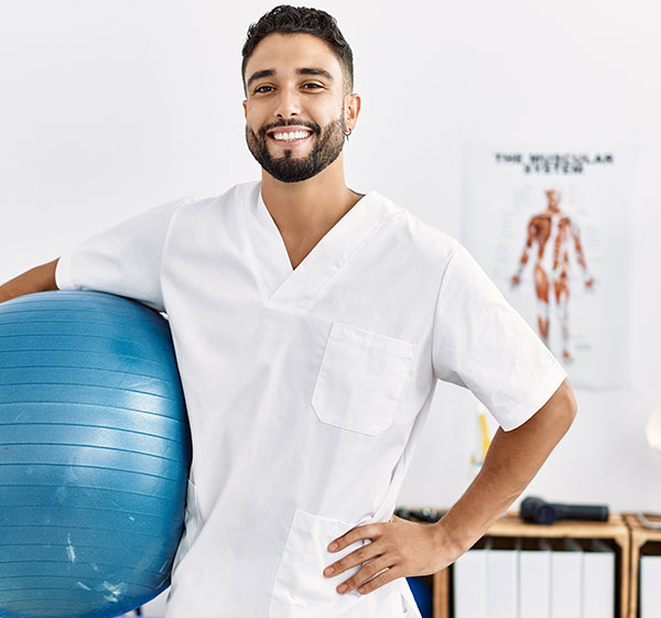 Physiotherapist holding exercise ball AdobeStock