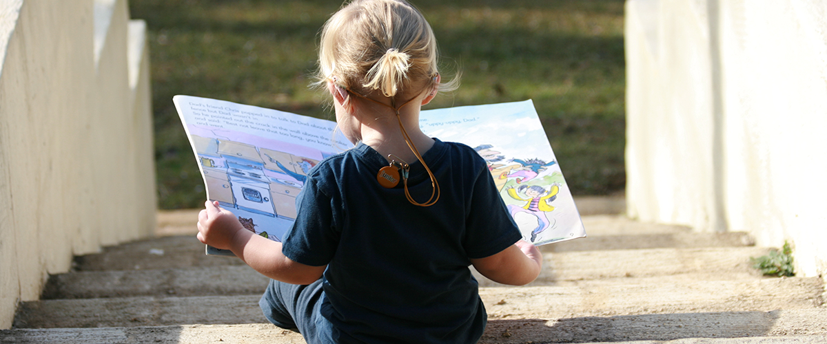 Young girl reading on steps