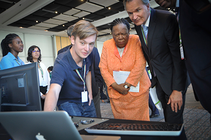 Physics student Matthew Spoor showing his work to Minister Naledi Pandor.