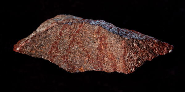 Blombos Cave drawing with ochre pencil on silcrete stone. Credit: Craig Foster