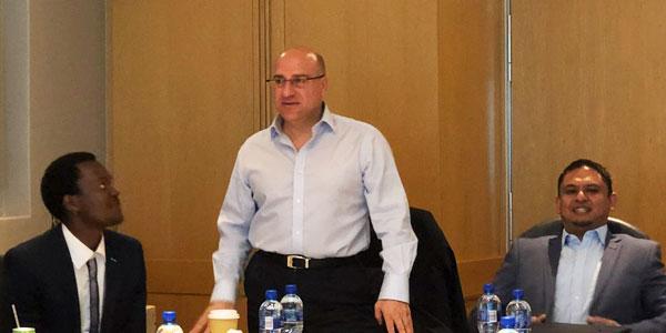 Dr. Stavros Nicolaou from Aspen Pharmacare stands to speak to PharmApprentice contenders flanked by Prof. Yahya Choonara, Director and Head of Wits Pharmacy (right in profile) with members of the top three PharmApprentice teams during their elevator pitches in Aspen boardroom in Midrand