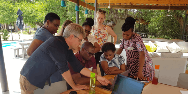 students and lecturer around laptop