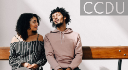 Young man and woman sitting on bench together