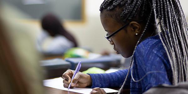 Student in classroom taking notes