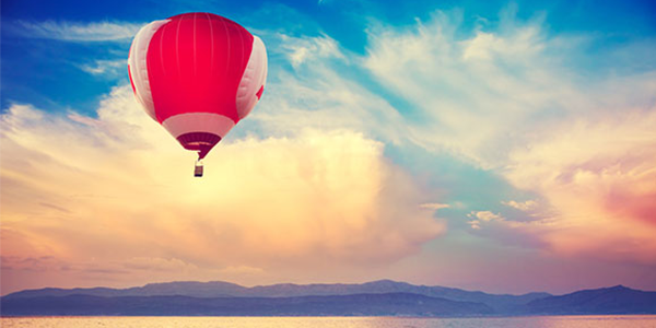 Hot air balloon drifting on shoreline