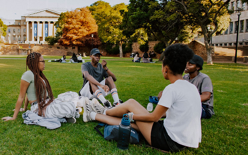 Students talking on the Library Lawns with Great Hall in distance