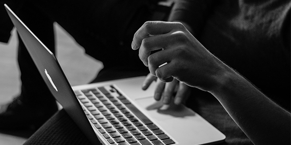 BW image of someone working on laptop computer
