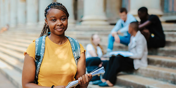 Student holding book in front of Great Hall