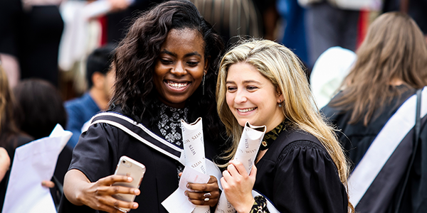 Two Wits graduates holding degree certificates © LM