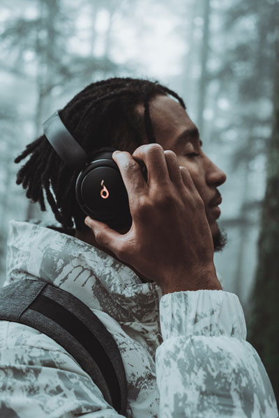 Man holding hands up to headphones